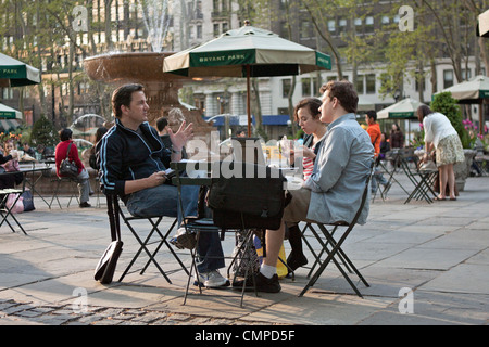 Persone discutere di affari a una tabella in Bryant Park di New York City. Foto Stock