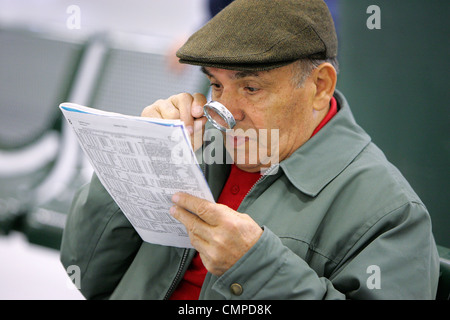 Un uomo legge il racing form in Suffolk Downs a Boston, Massachusetts Foto Stock