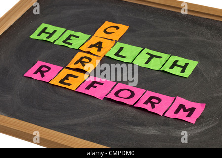 Della riforma sanitaria crossword - colorata sticky notes su una scuola lavagna con gesso bianco texture Foto Stock