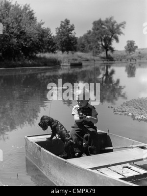 1940s ragazzo con un nero cocker spaniel PESCA IN BARCA SUL LAGO Foto Stock
