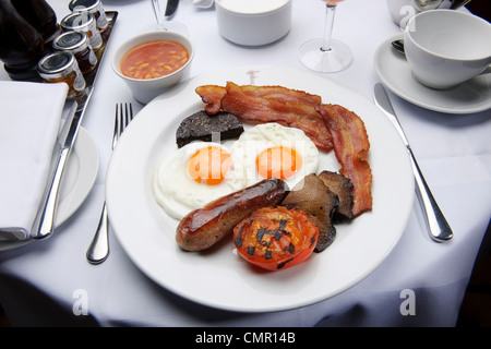 La completa prima colazione inglese fry up uova e bacon ristorante cibo malsano cucchiaio di grasso Foto Stock