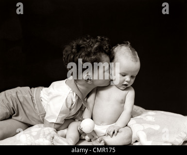 1940s DAI CAPELLI RICCI BOY TODDLER E PENDENTE KISSING simpatico baby Foto Stock