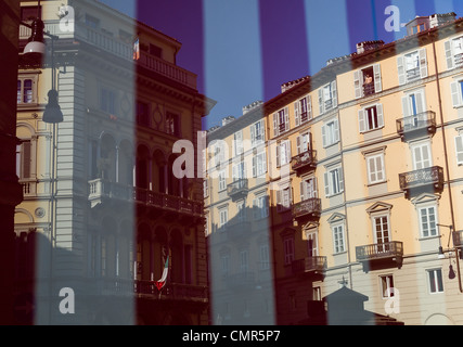 Viaggiare il Negozio di riflessione della finestra mostra le strade di Torino inondata di sole intermediato con strisce rosse e bianche da dentro il negozio - Italia Foto Stock