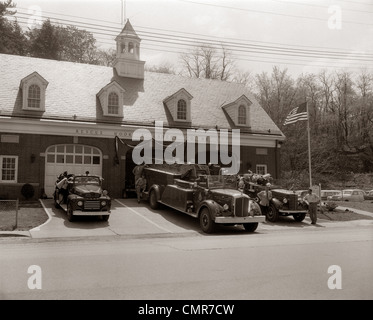 Anni Cinquanta anni sessanta volontario vigile del fuoco e il fuoco di camion parcheggiato di fronte la stazione dei vigili del fuoco Foto Stock