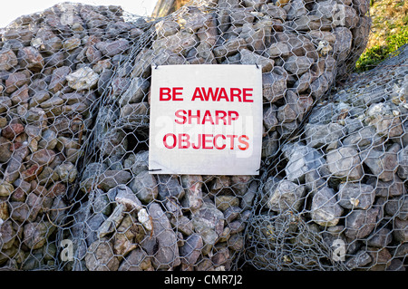 gabioni, attenzione oggetti appuntiti segno. Foto Stock