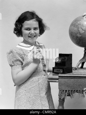 Trenta Bambini ragazza sorridente mettere soldi moneta nella cassa giocattolo banco registri Foto Stock