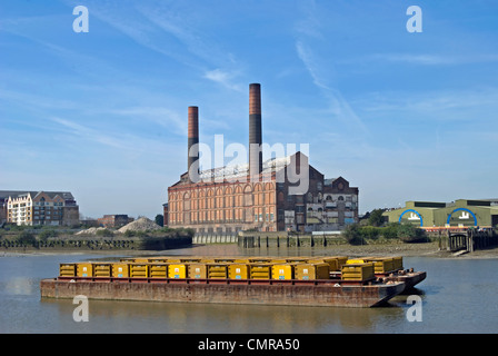 L'ex lotti road stazione di potenza, visto attraverso il fiume Tamigi in Battersea, con una bettolina in primo piano Foto Stock