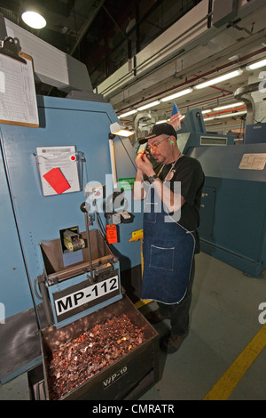 Denver, Colorado - un lavoratore ispeziona finito di penny monete presso la United States Mint. Foto Stock