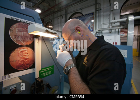 Denver, Colorado - un lavoratore ispeziona finito di penny monete presso la United States Mint. Foto Stock