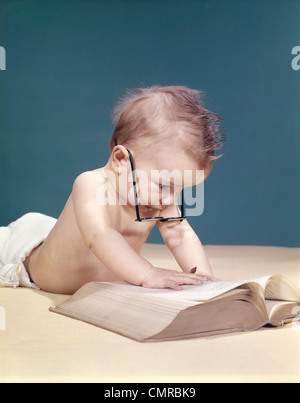 Anni sessanta FUNNY BABY indossando occhiali oversize LETTURA BIG BOOK Foto Stock