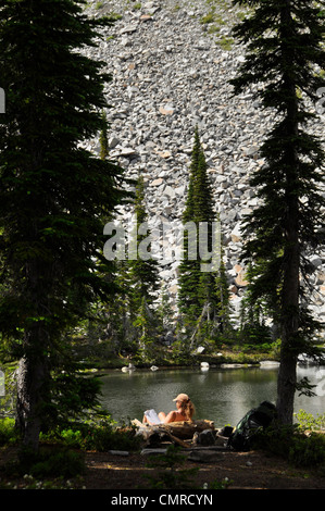 Backpacker rilassante con un libro, Wallowa Mountains, Oregon. Foto Stock