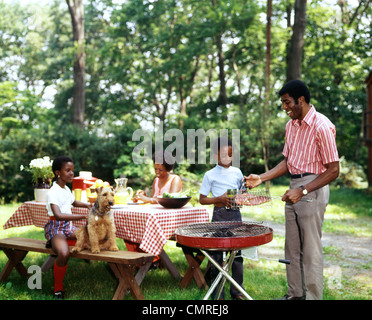 Anni Settanta famiglia americana africana BACKYARD PICNIC BARBECUE Foto Stock