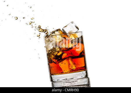 Splash in vetro con il whiskey e cubetti di ghiaccio su sfondo bianco Foto Stock