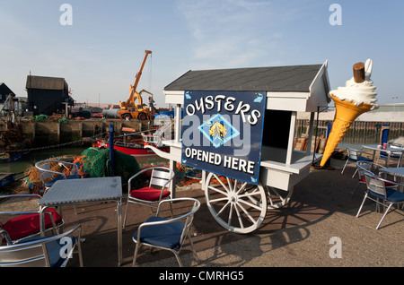 La città balneare di Whitstable che mostra il porto di lavoro e posto a sedere all'esterno. Foto Stock