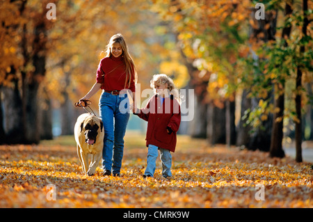 La madre e il bambino a piedi un cane in autunno Foto Stock
