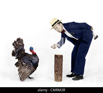 1930s 1940s uomo carattere con ascia cercando di catturare un tacchino del Ringraziamento Foto Stock