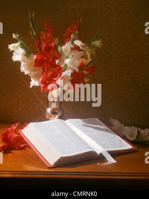 Vaso in argento di rosso e bianco fiori GLADIOLA con la Bibbia aperta a libro di Matteo Foto Stock