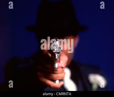 1970 anni settanta sfocata fuori fuoco uomo gangster criminale di puntamento pistola canna direttamente verso la lente Foto Stock