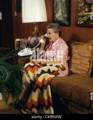 Anni ottanta anziani donna seduta sul divano parlando al telefono Foto Stock