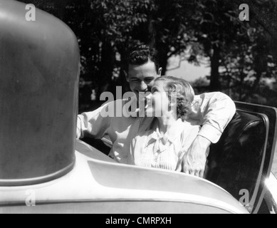 1930 matura nel retro RUMBLE DELLA PARTE POSTERIORE DEL SEDILE DI VETTURA UOMO CON BRACCIO ATTORNO ALLA DONNA Foto Stock