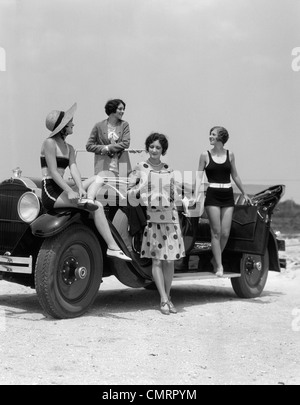 1920s 1930 QUATTRO DONNE IN ABITI E COSTUMI DA BAGNO riuniti intorno a cabriolet TOURING CAR A SEASHORE BEACH Foto Stock