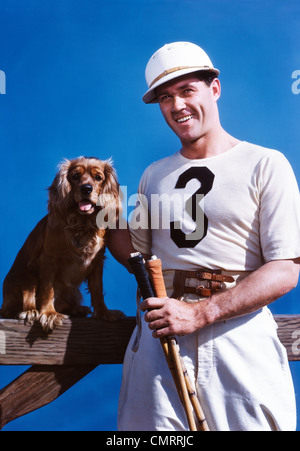 Anni Cinquanta uomo sorridente giocatore di polo in posa con cocker spaniel cane guardando la fotocamera Foto Stock