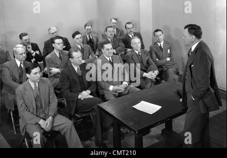 Trenta anni quaranta anni cinquanta RIUNIONE DI UN GRUPPO DI UOMINI DI AFFARI DI VENDITORI CHE OPERANO IN UNA CLASSE PER UN SALES TRAINING LEZIONE Foto Stock