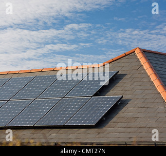 Pannelli solari fotovoltaici montati su un tetto di ardesia di residenziale o casa privata Foto Stock