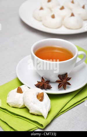 In casa meringhe con mandorle e tazza di tè, shallow dof. Incentrato su meringhe. Foto Stock