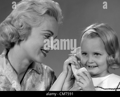 Anni Cinquanta anni sessanta madre guarda la figlia parlando al telefono Foto Stock