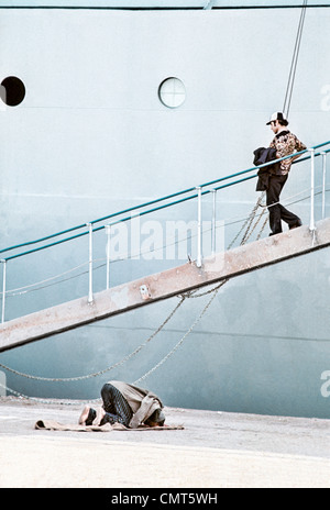 IRAN, BANDAR SHAHPUR: musulmana lavoratore dock si inginocchia verso la Mecca per la preghiera quotidiana accanto a una nave cargo schierate per caricare il carico. Foto Stock