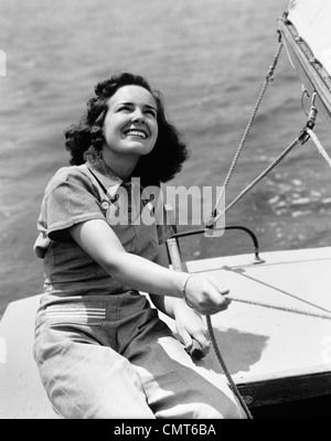 1940s donna sorridente marinaio IMBARCAZIONE A VELA ALL'APERTO Foto Stock