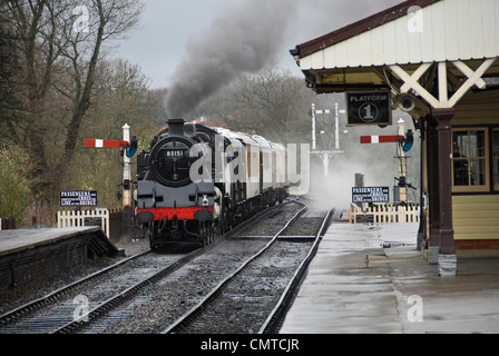 Locomotiva a vapore tirando in stazione ferroviaria a patrimonio Bluebell Steam Railway in East Grinstead. Foto Stock