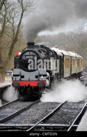 Locomotiva a vapore tirando in stazione ferroviaria a patrimonio Bluebell Steam Railway in East Grinstead. Foto Stock