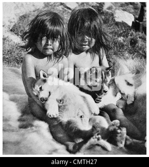 1925 Eschimese cane Megishoo Shooegingwa e giocare con i cuccioli seduto su un Bearskin Foto Stock