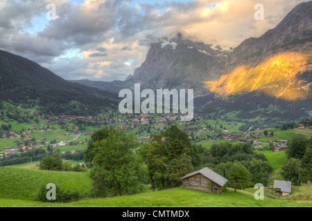 Città alpina famosa Grindelwald in valle al tramonto nella parte anteriore del Monte Eiger north face, Svizzera Foto Stock