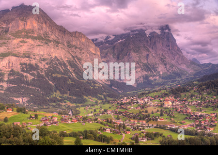 Città alpina famosa Grindelwald in valle al tramonto nella parte anteriore del Monte Eiger north face, Svizzera Foto Stock