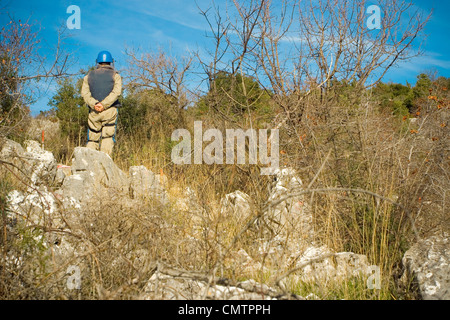 Un deminer in azione la pulizia dell'area da miniere. Foto Stock