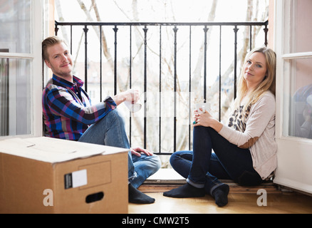 Metà adulto giovane nella loro nuova casa Foto Stock