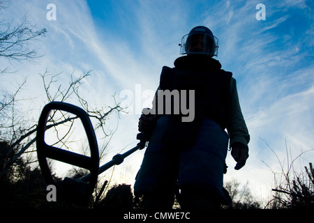 Un deminer in azione la pulizia dell'area da miniere. Foto Stock