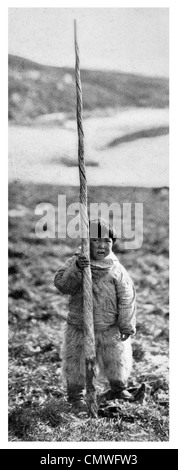 1925 Eschimese bambino con il brosmio elicoidale di un Narwhal Monodon monoceros Foto Stock