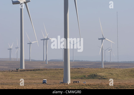 Immagine che mostra le dimensioni e la scala di turbine eoliche e farm. Vi è un furgone e persone nella parte inferiore della prima turbina. Foto Stock