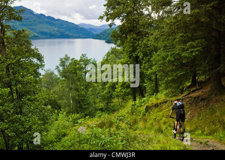 Mountain biker sulla West Highland Way Scozia, scendendo al di sopra Loch Lomond Foto Stock