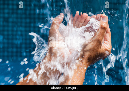 Versare acqua nelle mani di una donna Foto Stock