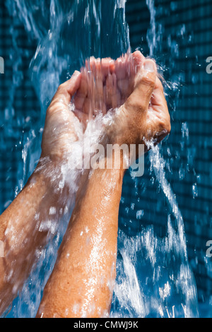 Versare acqua nelle mani di una donna Foto Stock