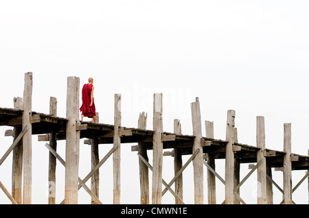 Monaco attraversando U Bein ponte in teak, Mandalay Myanmar Foto Stock