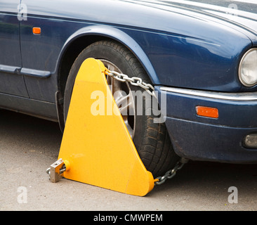 A morsetto di bloccaggio di ruota fissato alla ruota di un automobile Foto Stock