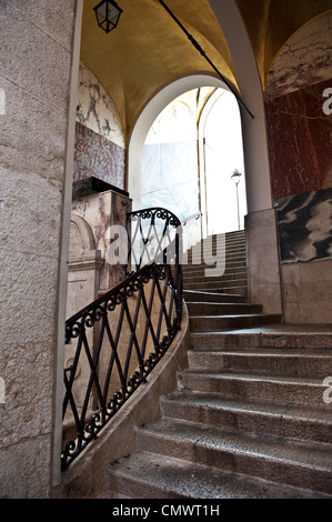 Scala a chiocciola che conduce fino a un portale ad arco. Foto Stock