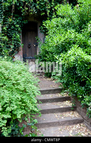 Un po' della porta d'ingresso di un camminamento segreto e circondato da alberi. Foto Stock