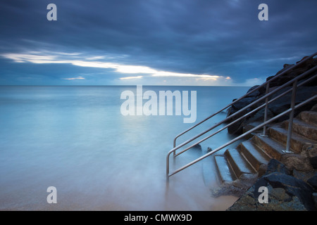 Lavaggio onde su gradini che conduce al mare. Machans Beach, Cairns, Queensland, Australia Foto Stock